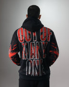 Espalda del buzo negro del conjunto Liberty con la frase OUT OF MANY, ONE en letras rojas
