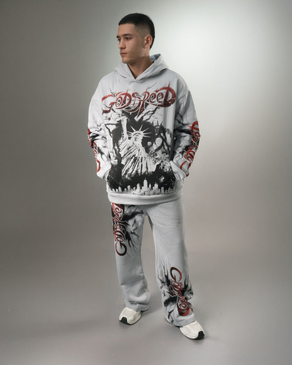 Hombre con el conjunto Liberty gris completo, buzo y pantalón con la Estatua de la Libertad estampada en negro